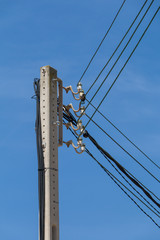 Powerlines and isolators at a pole in front of blue sky