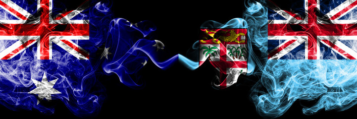 Australia vs Fiji smoky mystic flags placed side by side. Thick colored silky smokes combination of national flags of Australia and Fiji