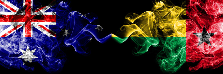 Australia vs Guinea Bissau smoky mystic flags placed side by side. Thick colored silky smokes combination of national flags of Australia and Guinea Bissau