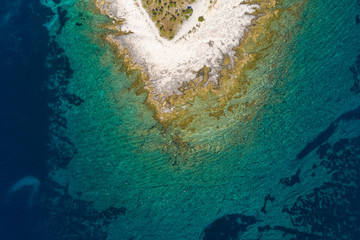 Aerial overhead shot of rocky seashore with crystal clear blue water on the island of Dugi Otok in Croatia