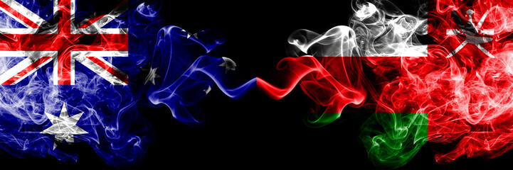 Australia vs Oman, Omani smoky mystic flags placed side by side. Thick colored silky smokes combination of national flags of Australia and Oman, Omani