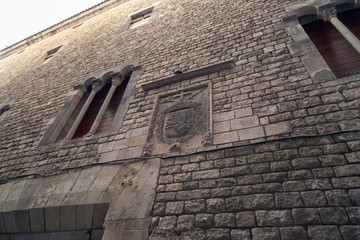 Barcelona, Spain. Historic building Palace, Palau Reial Major and Inquisition shield in wall stone, gothic quarter.