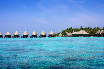 Fototapeta na wymiar houses over transparent quiet sea water- tropical paradise, Maldives
