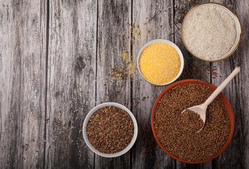 Rice, buckwheat, corn grits with wooden spoon in cups on wooden background. superfood