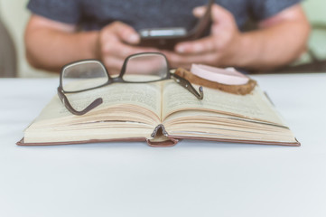 man reading a book at the table, having a snack while reading, a short break