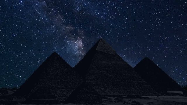 pyramids in silhouette with time lapse of stars