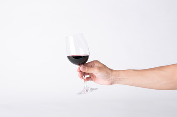 Man hand holding a wine glass on a gray background.