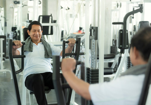 Asian Senior Man Exercise Lifting Dumbbell In Fitness Gym. Elderly Healthy Lifestyle.