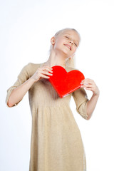 Beautiful girl holding heart in arms.