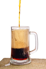 pouring dark beer in jar with foam on stone over white  background, Oktoberfest concept