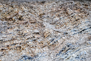 Abstract industrial background with the texture of the surface of a heap of natural multi-colored stone, crushed stone, cobblestone, gravel on a slope in a quarry