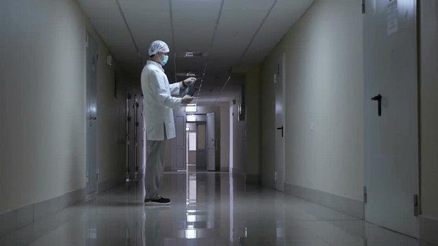 doctor in uniform in the corridor of the clinic examines X-ray, X-ray examination