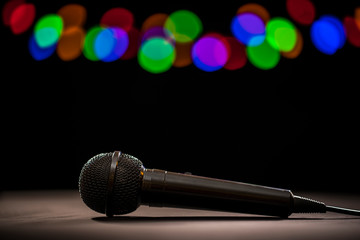 Mic drop! A microphone lying on the floor in the spotlight on a dark stage.