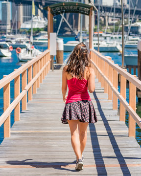 Young woman walking to the bay showing the backside. 