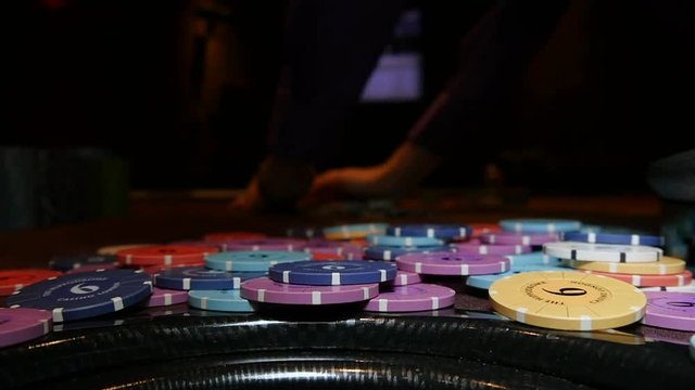Slow motion shot of casino chips are swept away after a loss