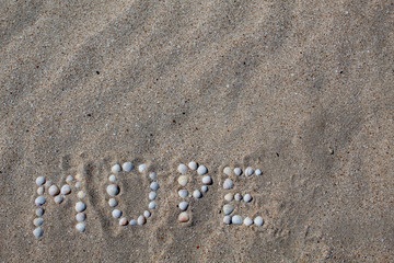 The word sea, in Russian, is laid out on the sand with shells. There is free space, space for text. Background.