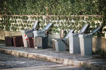 opened trash cans, garbage cans just emptied on the sidewalk