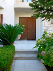Fototapeta na wymiar Athens Greece, contemporary house entrance wooden door with foliage and stairs