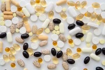 Close-up of scattered colorful pills on white table. Mock up for advertising or web background. Health care, Medical or Pharmacy concept.