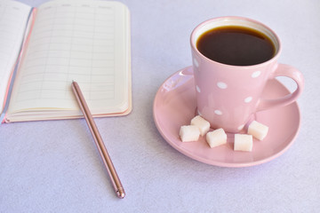 Notebook with pen and a Cup of black coffee on white background. business minimal concept for women.