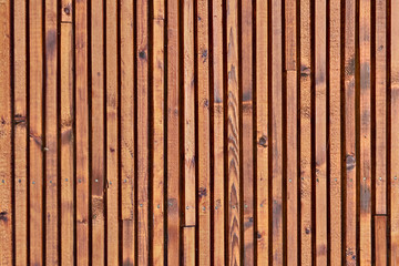 Smooth dark brown boards with knots. Surface texture of wooden slats. Background of polished wood strips.