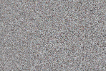 Background in the form of polished stones of gray, black, white and brown colors. Texture of small heterogeneous stones.