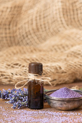 Lavender flowers, bath salt and lavender oil on a wooden background.