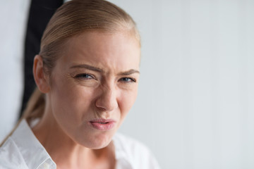 Emotion Concept. Woman standing isolated on white disgusted close-up