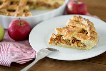 food, culinary and baking concept - close up of apple pie and fork on plate