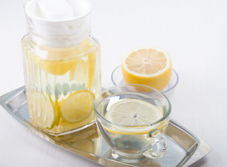   Lemon water in a glass jug and in a glass cup