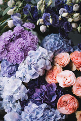Beautiful blossoming flowers (roses, hydrangeas, carnations, eustoma) in blu, antique blue and peach colours at the florist shop