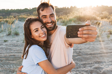 Beautiful young smiling couple spending time at the beach