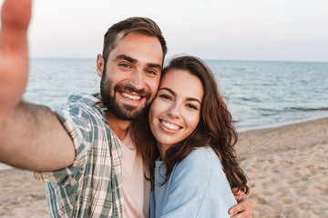 Beautiful young smiling couple spending time at the beach