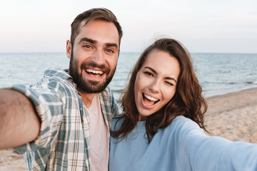 Fototapeta premium Beautiful young smiling couple spending time at the beach