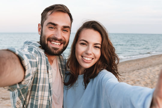Beautiful young smiling couple spending time at the beach