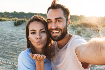 Obraz premium Beautiful young smiling couple spending time at the beach