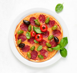 Pizza with salami and olives, top down view
