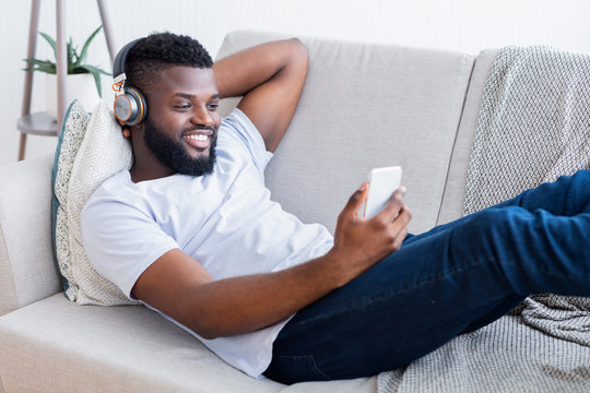 Black Man In Headphones Watching Movie On Smartphone