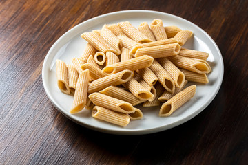 pasta, wholemeal penne on white plate