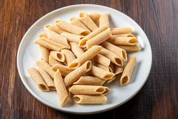 pasta, wholemeal penne on white plate