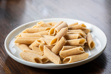 pasta, wholemeal penne on white plate
