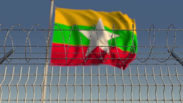 Waving flag of Myanmar behind barbed wire fence. Conceptual loopable 3D animation