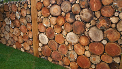A decorative garden wall of sliced logs
