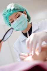 Chinese Female dentist focus on patient mouth