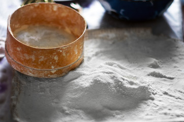 Traditional Wooden Sieve or Sifter, White Flour on a Tray, Mixing Bowl on the Table.
