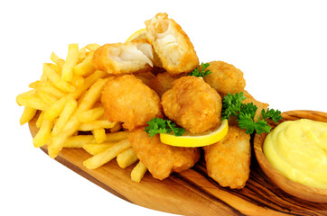 Battered cod nugget bites with potato French Fries and mayonnaise dip on an olive wood serving board isolated on a white background