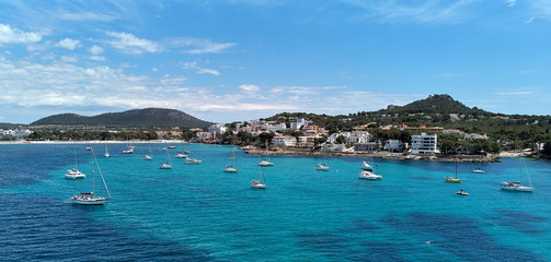 Fototapeta na wymiar Waterside aerial photo coastline of Santa Ponsa town in the south-west of Majorca Island. Located in the municipality of Calvia, moored yachts on the turquoise tranquil bay of Mediterranean Sea, Spain