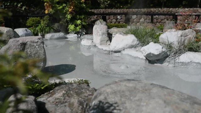 landscape view of gray mud boiling bubble hell hot springs at Japan.