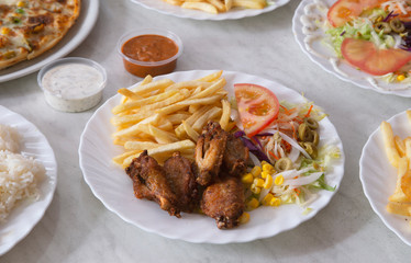Plate of chicken wings with chips and salad