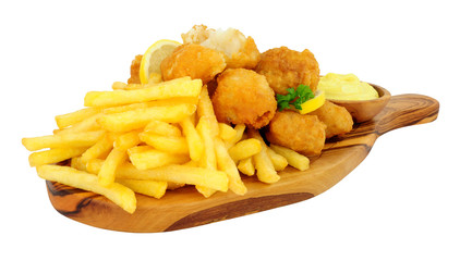 Battered cod nugget bites with potato French Fries and mayonnaise dip on an olive wood serving board isolated on a white background